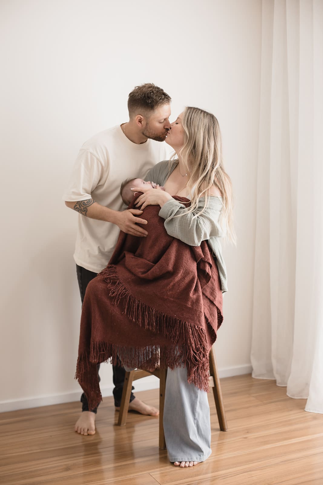 Parents holding newborn baby during a family newborn photography session in Melbourne